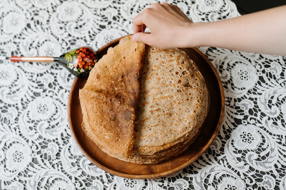 Stack of thin Russian blini pancakes with red caviar and sour cream