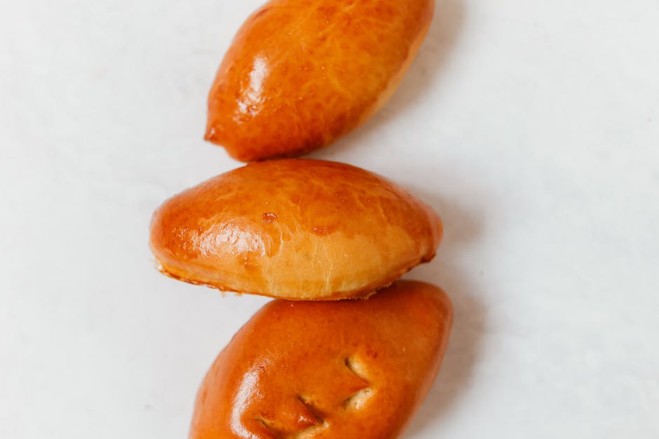 Golden baked Russian pirozhki hand pies arranged on a wooden board