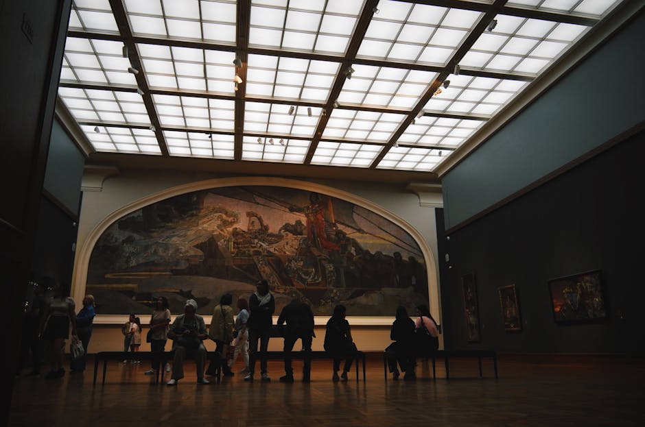 Visitors admiring large-scale paintings in a dimly lit gallery hall at the Tretyakov museum in Moscow